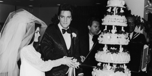 1st May 1967: American rock n' roll singer Elvis Presley (1935 - 1977) cuts his wedding cake with his wife, Priscilla. Photo / Getty