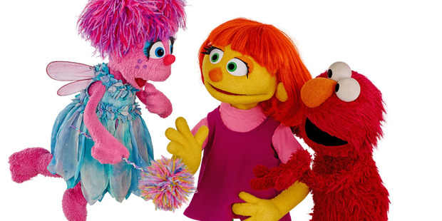 Julia, centre, shown with friends Abby Cadabby and Elmo, debuts April 10 on Sesame Street. Photo / Zach Hyman, Sesame Workshop