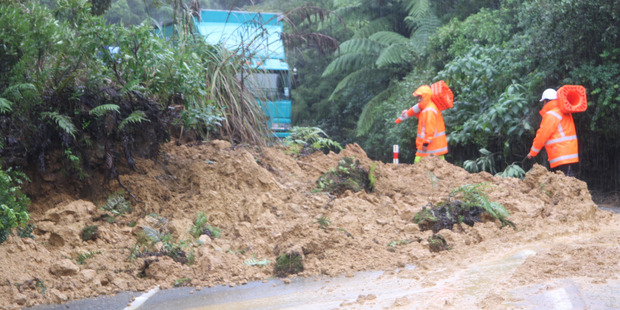 Road workers preparing to clear the slip that closed SH1 on the northern side of the Mangamuka Gorge on Thursday. Tracks made by light vehicles that travelled around the slip can be seen at the right.