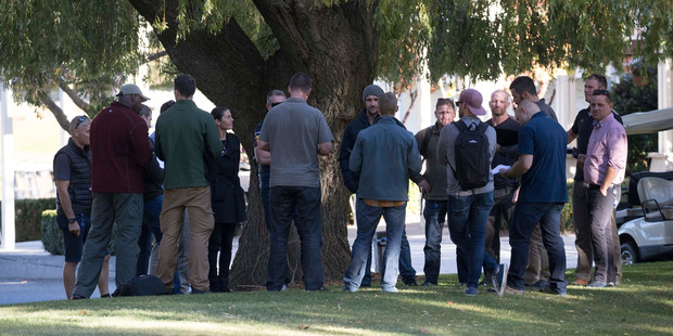 A group of 18-20 plain clothed police and security outside reception at Millbrook Resort, Arrowtown. Photo / Brett Phibbs