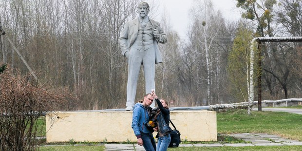 Journalists take a selfie in front of the monument of Soviet state founder Vladimir Lenin in Chernobyl, Ukraine. Photo / AP
