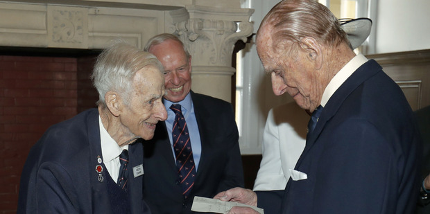 Prince Philip, Duke of Edinburgh reads a letter he wrote to former naval commander Keith Evans, left, now aged 97, after the announcement of his engagement to Queen Elizabeth. Photo / Getty