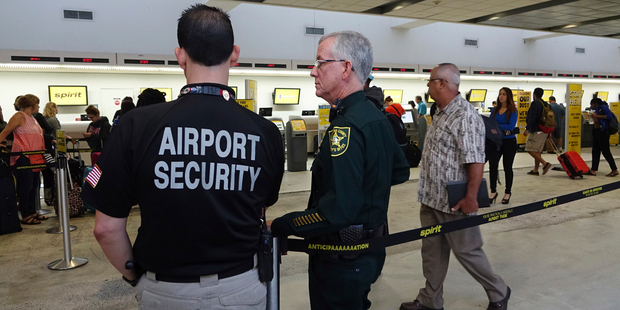 Airport Security and a Broward Sherriff's Deputy keep an eye on the line at Spirit Airlines. Photo / AP