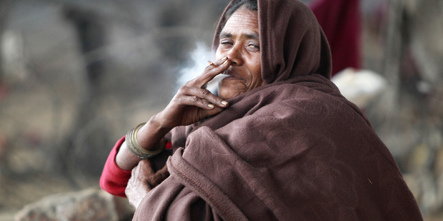 A homeless Indian woman smokes in Jammu, India. Photo / AP