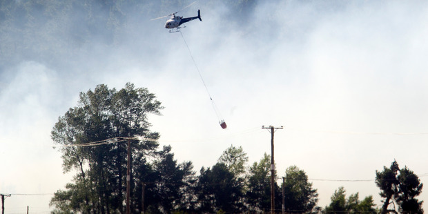 A helicopter helps to put out the blaze. Photo/Ben Fraser