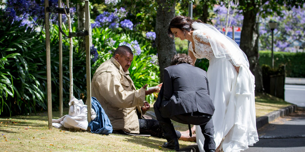 Bronia Tindall and Fabrizio Clementi share a slice of their wedding cake with Miller Patane outside The Community of Saint Luke Church in Remuera. Photo / Ben Franks/Steve May, one2one Photography