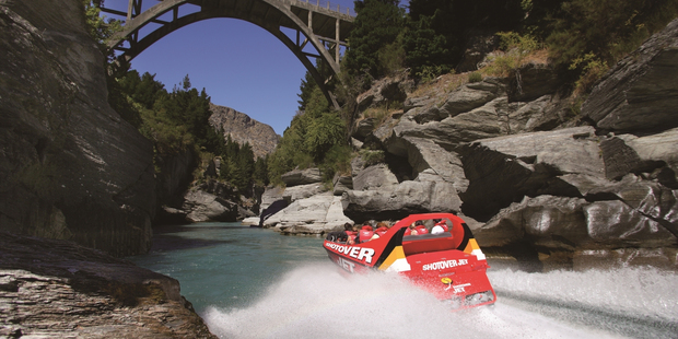 The Shotover Jet heads for Edith Cavell Bridge, Queenstown. Tourists are flocking to New Zealand putting pressure on infrastructure.