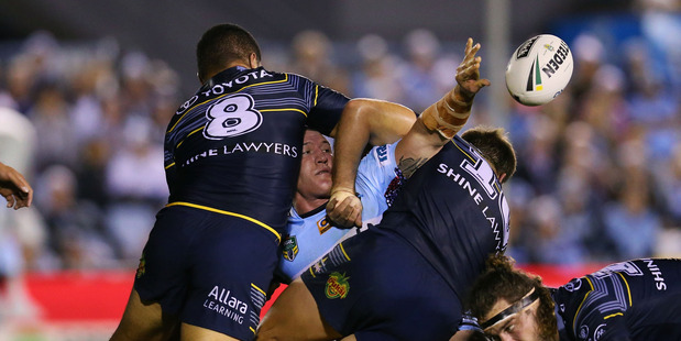 Paul Gallen of the Sharks passes the ball among three Cowboys tacklers. Photo / Getty