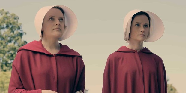 Elisabeth Moss,left, is draped in a red cloak in a scene from The Handmaid's Tale.