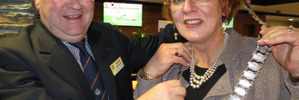 Outgoing Queenstown Rotary president Keith McIntosh hands the chains of office to Monica Mulholland. Photo / Philip Chandler