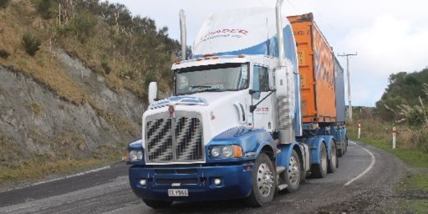 One of many heavy trucks spraying loose gravel out of potholes on the Saddle Road.