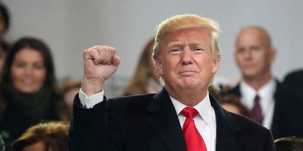 Trump waves to the crowd from the inaugural parade revieing stand in front of the White House. Photo / Getty Images