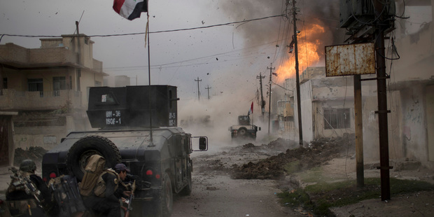 A car bomb explodes next to Iraqi special forces armored vehicles in November as they advance towards Islamic State positions in Mosul, where Zaid Al-Jarrah was born. Photo / AP