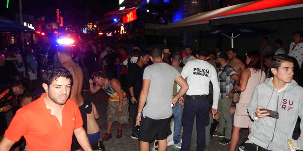 In this photo released by Por Esto de Quintana Roo, people react after a shooting at the outdoor venue Blue Parrot nightclub in the Caribbean coast resort of Playa del Carmen, Mexico. Photo / AP