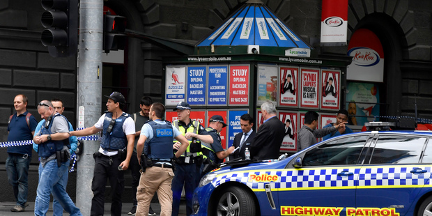Police listen to witnesses near the site where the car struck pedestrians. Photo / AP