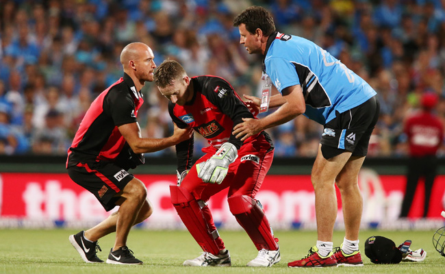 Peter Nevill of the Melbourne Renegades is helped by medical staff after he was hit by a bat. Photo / Getty