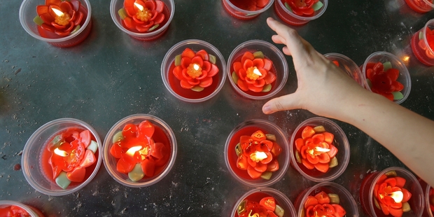Ethnic Chinese Thais place candles in a Bangkok temple. Photo / AP
