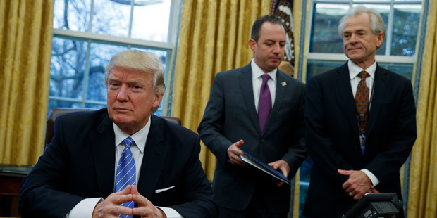 National Trade Council adviser Peter Navarro, right, and White House Chief of Staff Reince Priebus, centre, with US President Donald Trump. Photo / AP