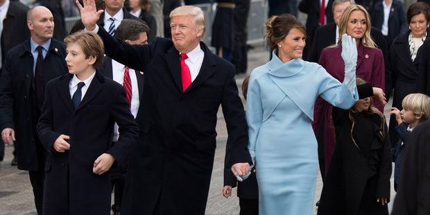 President Donald Trump and first lady Melania Trump, along with their son Barron, walk in their inaugural parade. Photo / Getty Images