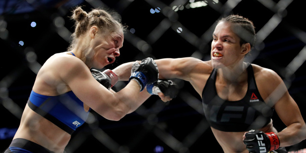 Amanda Nunes connects with Ronda Rousey in the first round of their women's bantamweight championship mixed martial arts bout at UFC 207. Photo/AP Photos