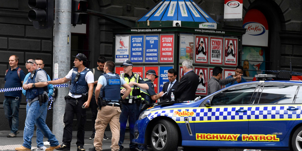 Police listen to witnesses at the scene. Photo / AP