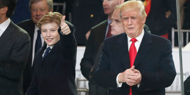 President Donald Trump, right, and his son Barron react as they view the 58th Presidential Inauguration parade for President Donald Trump in Washington. Photo / AP