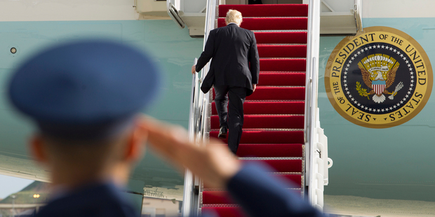 President Donald Trump is saluted as he walks up the stairs. Photo / AP