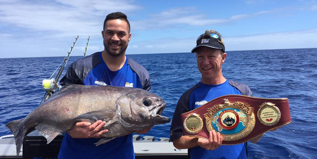 Joseph Parker with ITM Fishing Show host Matt Watson, holding the WBO heavyweight title belt. Photo / Joseph Parker - Facebook