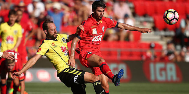 Andrew Durante of the Wellington Phoenix tackles George Mells of Adelaide United during their game in searing conditions. Photo / Getty