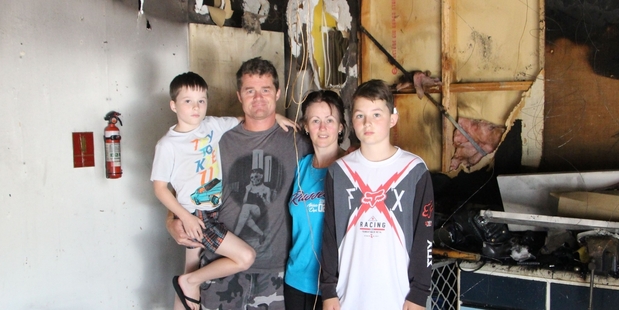 Luke, Trent, Kathryn and Cole stand in the burned out garage, where the fire started.