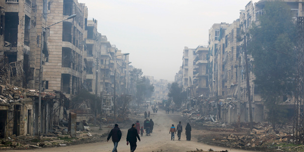 Residents walk through the destruction in the once rebel-held Salaheddine neighbourhood of eastern Aleppo, Syria. Photo / AP