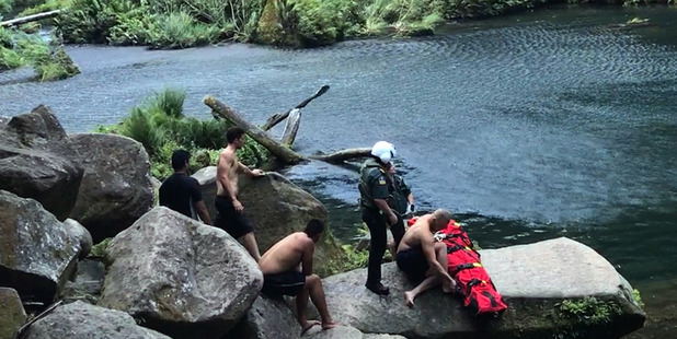 Paramedics tend to the man who was injured after jumping from Omanawa Falls. Photo/supplied