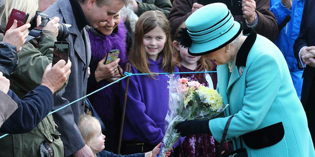 Britain's Queen Elizabeth II stops to receive flowers from 3-year old Jessica Atfield, after the queen and her husband Duke of Edinburgh, attended church on Sunday. Photo / AP