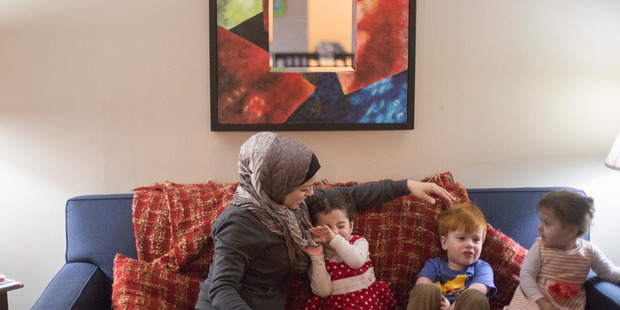 Fatema Aljasem and her daughters, from left, Shahaad and Ahed, and Leor Abraham sit on the couch at the Aljasem's apartment in Omaha, Nebraska. Photo / The Washington Post