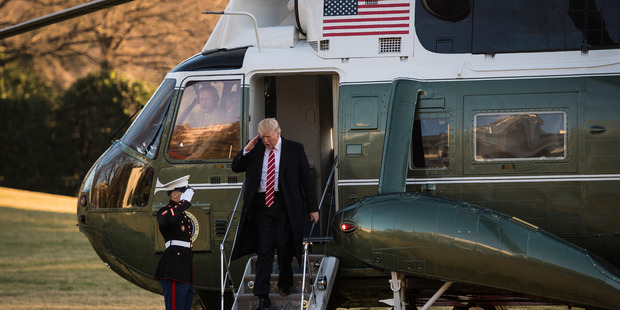 US President Donald Trump salutes as he disembarks Marine One on the South Lawn of the White House in Washington. Photo / Washington Post