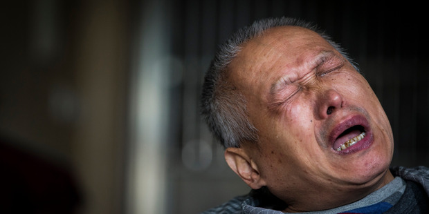 Bo Tu cries over the death of his only child in his Wuhan home. "Not a single day has been spent without pain and sorrow," he says. Photo / Mike Scott
