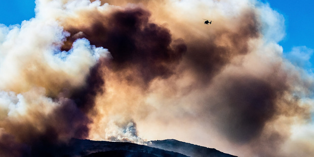 Firefighters and helicopters fight the blaze on the Port Hills Christchurch. Photo / Martin Hunter - Christchurch Star