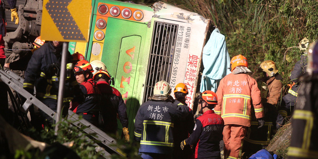 Members of rescue team at the scene where a bus collided with a car on a highway in Taipei, Taiwan. Photo / AP