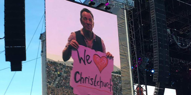 Bruce Springsteen held up a We love Christchurch sign, to applause from the crowd. Photo / Tania Gibson