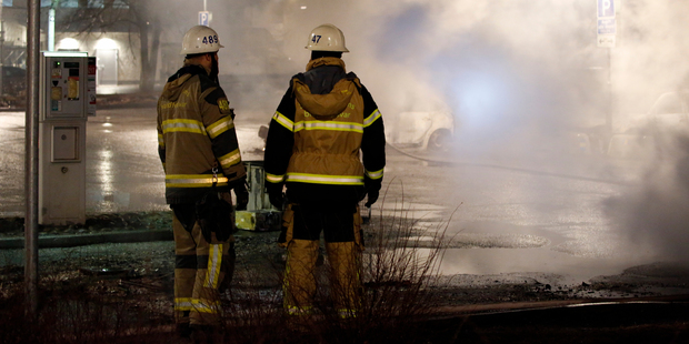 Firefighters survey the scene in the suburb of Rinkeby outside Stockholm. Photo / Christine Olsson/TT News Agency via AP