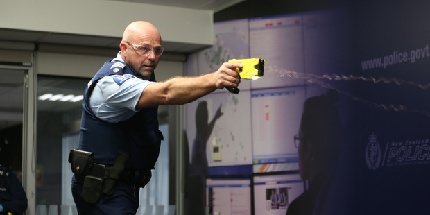 A police officer demonstrates the use of a taser at Police National Headquarters in Wellington. New Zealand Herald Photograph by Mark Mitchell.