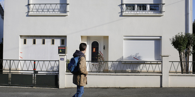 A boy passes by the house belonging to the missing Troadec family in Orvault, near Nantes, western France. Photo / AP