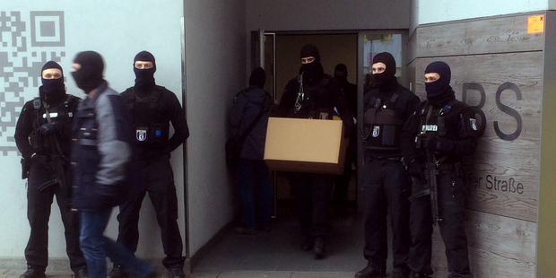 Police carry a box outside of a residential building in Berlin, Germany. The raids followed a decision by state authorities to ban an organisation that ran a mosque. Photo / AP