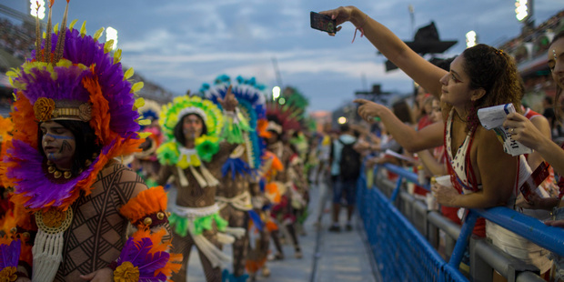 A woman takes a photo of the Beija Flor samba school parade during Carnival celebrations at the Sambadrome in Rio de Janeiro, Brazil. Photo / AP