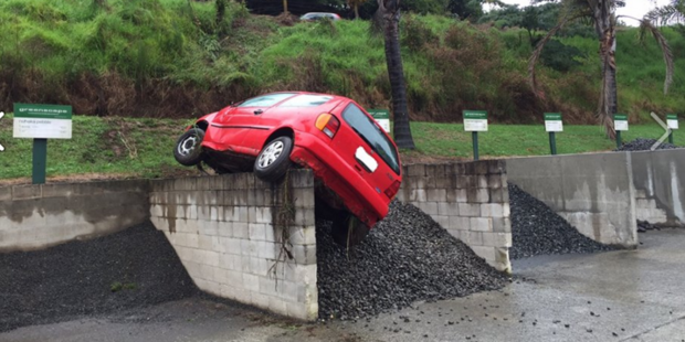 A car ended up in a precarious position in Cambridge after losing control in wet weather. Photo / Cambridge Police/Facebook