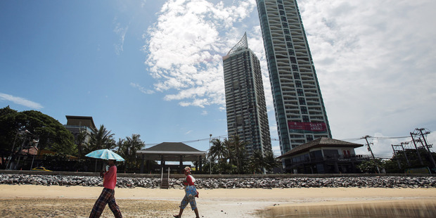 People walk past buildings on the Jomtien Beach area of Pattaya, Thailand. Photo / Dario Pignatelli