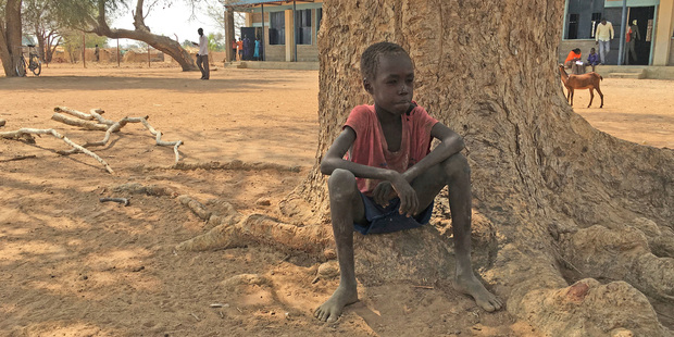 Thor Athiam, 9, sits outside of a classroom waiting under a tree in South Sudan. Famine has been declared in two counties. Photo / AP
