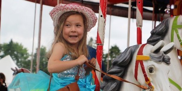 Isla Terrill is all smiles on the merry-go-round.
