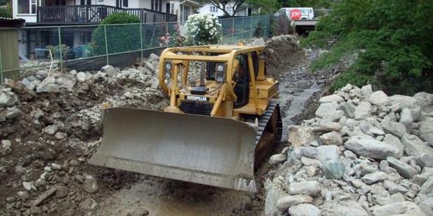 Bulldozers and excavators were being used by contractors in Reservoir Creek in the north end of Roxburgh yesterday afternoon to clear rocks from the area. Photo: Tom Kitchin