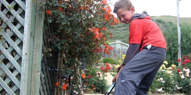 Roxburgh Area School pupil Eli Halker (10) helps clean the garden of a Tweed St house yesterday. Photos: Tom Kitchin